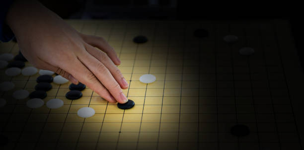 деталь женской руки, играющей в китайскую настольную игру - chess strategy business board room стоковые фото и изображения