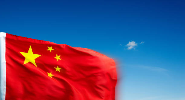 istock Chinese flag on pole waving in the wind against blue sky 1567477619