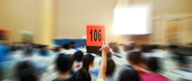 People holding up customer number pacing a bid stock photo