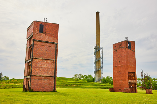 Image of Tiered grassy hill near old abandoned freight elevator buildings and distant watch tower