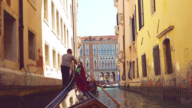 View from the front of the gondola of Venice canals and architecture of the city during ride along one of the canals in Venice, Italy.