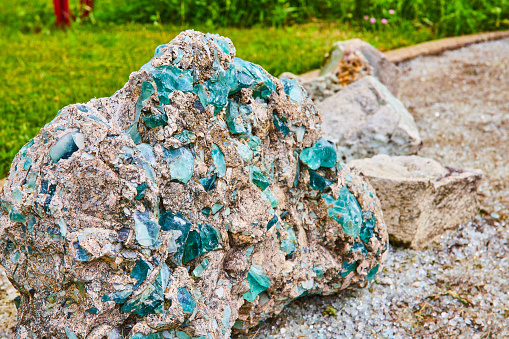 Image of Turquoise blue and sapphire glass embedded and fused to destroyed concrete rock with glassy ground