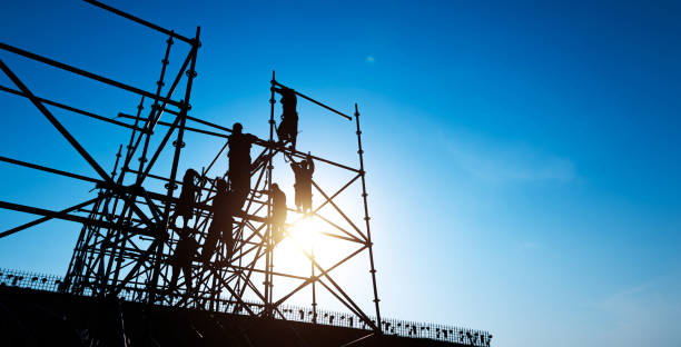 Group of construction workers working on scaffolding stock photo