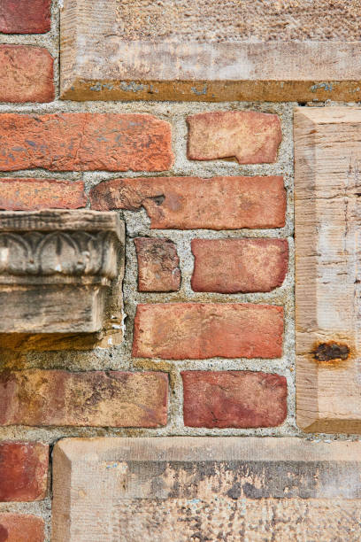 istock Various textures wall of mixed tan concrete blocks with faded red bricks and pillar protrusion 1567484287