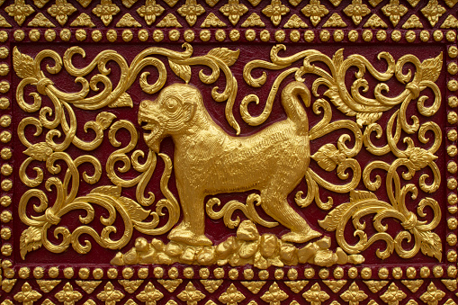 Antique gold stucco wall mounted in a Thai temple