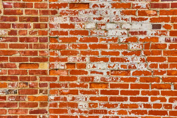 istock Wall of red bricks with unusual seem joining faded bricks with bright orange bricks 1567493978