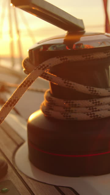 SLO MO Slow motion shot of winch with rope on sailboat during sunset