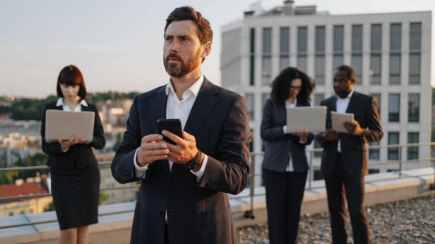 istock Multiracial investors using wireless gadgets on terrace 1567509369
