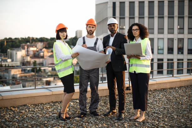 istock Multiethnic team posing on camera with laptop and layouts 1567509383