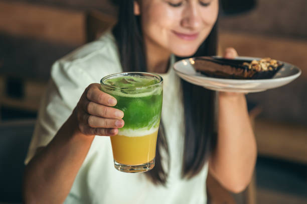 istock Close-up, lemonade and chocolate cake in female hands. 1567512354