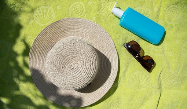 istock summer hat, brown sunglasses and body lotion , vacation concept.flat lay 1567517817