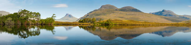 escocia highland picos montañosos que reflejan en el apacible loch - inverpolly nature reserve fotografías e imágenes de stock