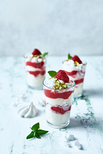 Raspberry, mascarpone and pavlova cookies dessert topped with honey and pistachios