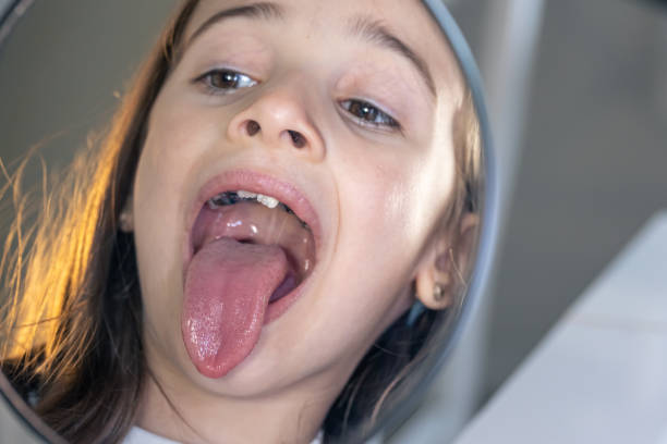 child shows his tongue closeup .