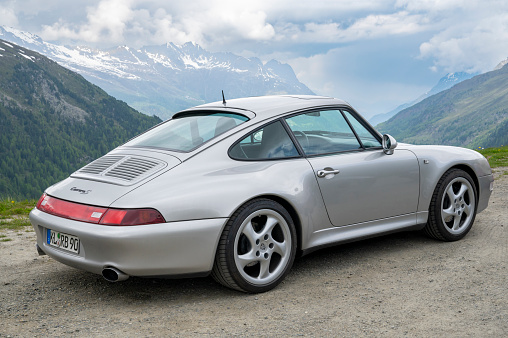 Porsche 911 generation 993 parked on the side of the road on the Timmelsjoch Mountain pass in the Austrian Alps.