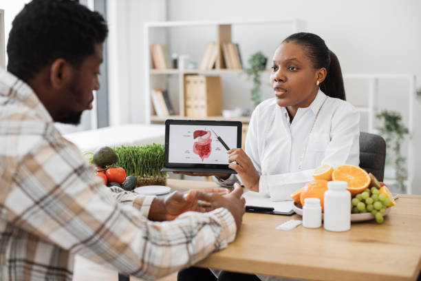 istock Woman holding tablet with GI tract while counseling client 1567549298