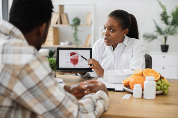 istock Woman holding tablet with GI tract while counseling client 1567549328