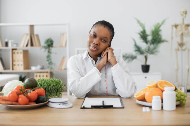 istock Lady in lab coat looking at camera in dietitian's office 1567549853