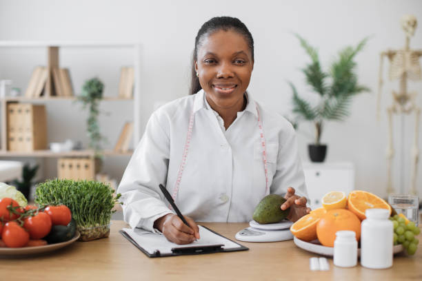 istock Dietitian measuring avocado on scale at office desk 1567549875