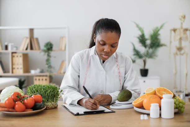 istock Dietitian measuring avocado on scale at office desk 1567549880