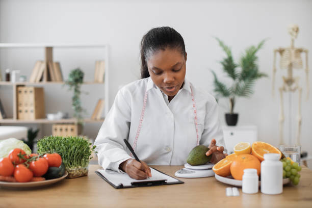 istock Dietitian measuring avocado on scale at office desk 1567549898