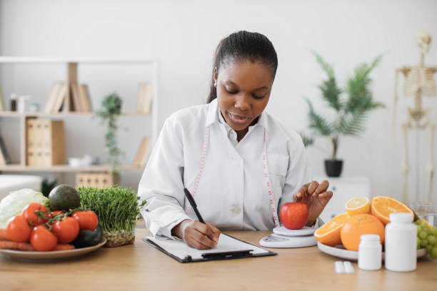 istock Professional assessing apple on scales in consulting room 1567550454