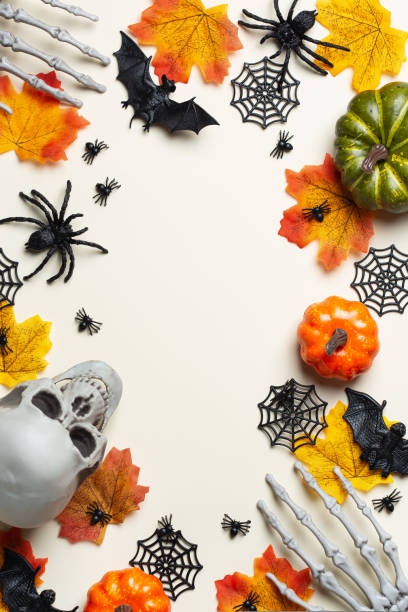 istock Halloween greeting card with pumpkin, skulls, bony hands and leaves 1567551041