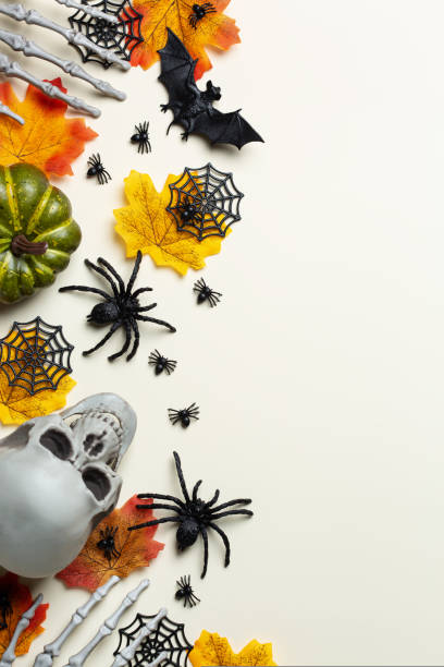istock Halloween greeting card with pumpkin, skulls, bony hands and leaves 1567552149
