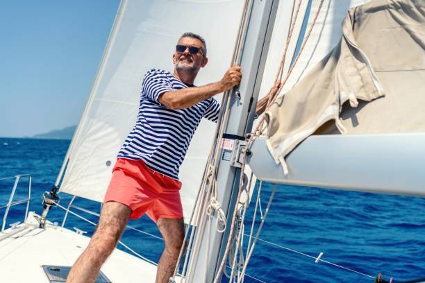 istock Mature man on sailboat 1567559789