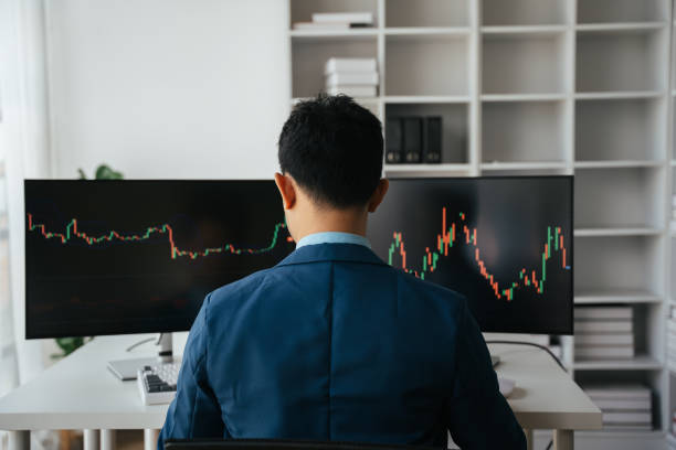 istock Young businessman holding hands on his face while sitting at the desk in creative office, stock market concept. 1567568937
