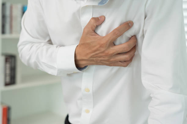hand hold chest with heart attack symptoms, asian man working hard have chest pain caused by heart disease, leak, dilatation, enlarged coronary heart, press on the chest with a painful expression agarre la mano en el pecho con síntomas de ataque cardíaco, hombre asiático que trabaja duro tiene dolor en el pecho causado por enfermedad cardíaca, fuga, dilatación, agrandamiento del corazón coronario, presión sobre el pecho con una expresión do