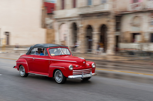 HAVANA, CUBA - OCTOBER 21, 2017: Old Car in Havana, Cuba. Panning. Retro Vehicle Usually Using As A Taxi For Local People and Tourist. Red Color