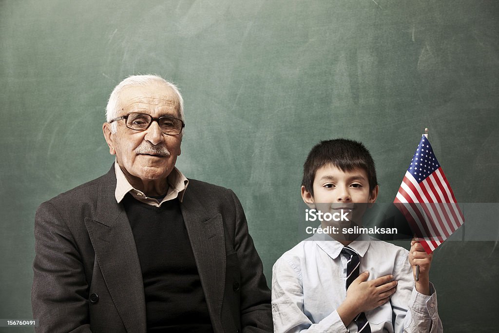 Starszy człowiek i mały chłopiec pozujących z Amerykańska flaga - Zbiór zdjęć royalty-free (Dziecko)