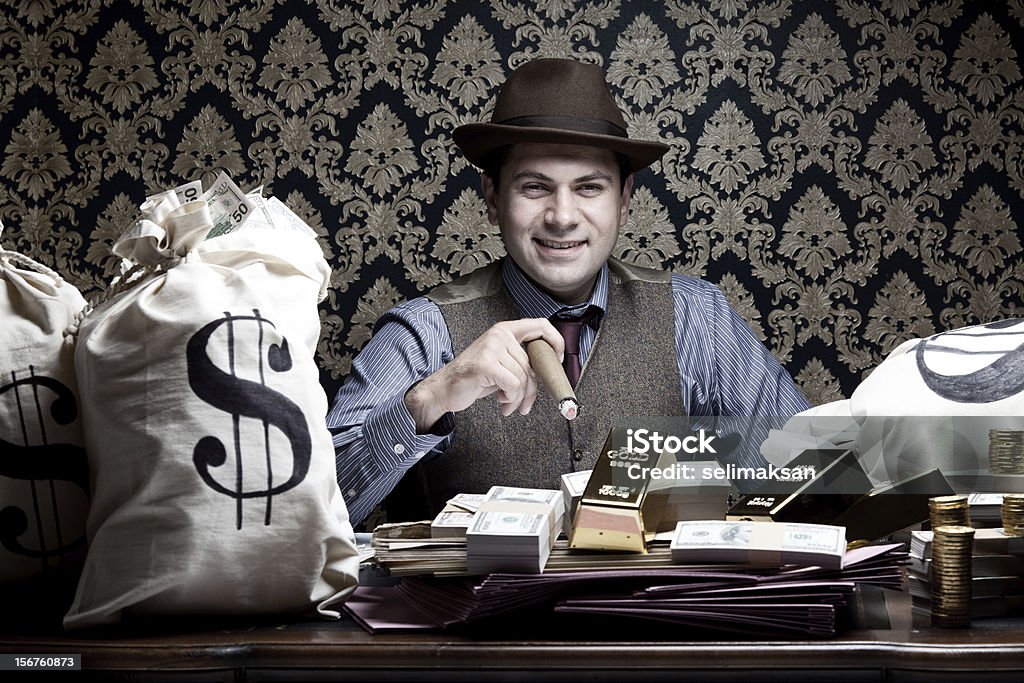 Rich man posing with money bags, gold and dollar bills Rich man posing with money bags and dollar bills Currency Stock Photo