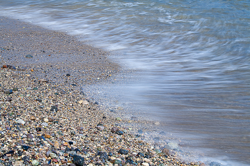 wet pebble stones and small waves at the beach