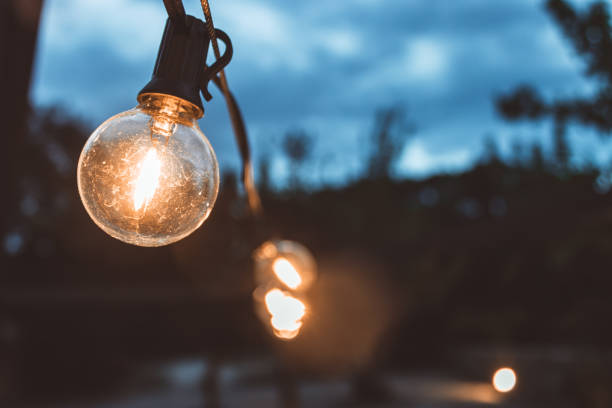 istock Light bulbs hanging on street 1567625569