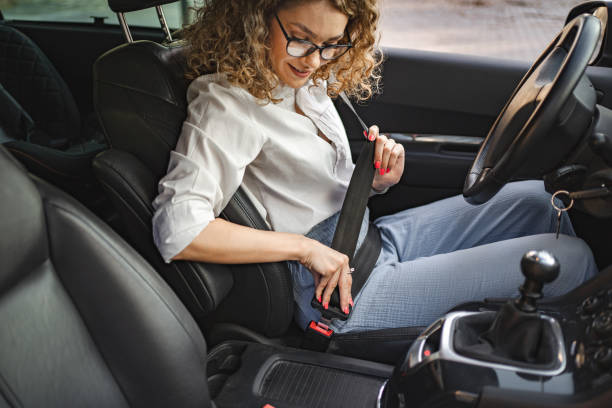 istock Young female driver adjusting seat belt before driving 1567628290