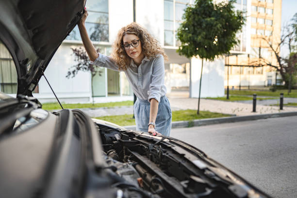 istock Woman checking car engine after breakdown 1567629555