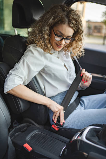 istock Young female driver adjusting seat belt before driving 1567629880