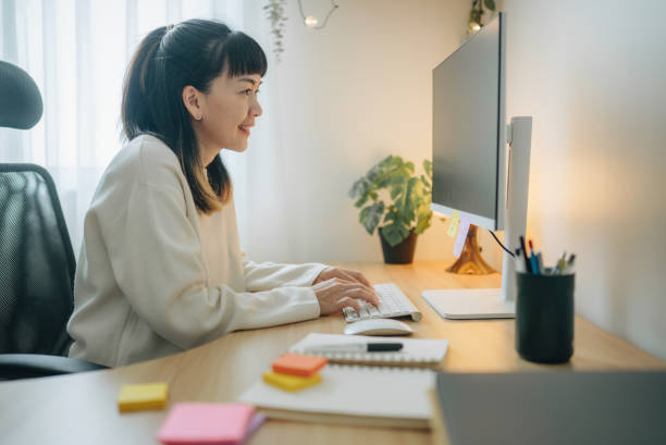 istock Asian businesswoman writing notes in her notebook behind her office desk 1567670125