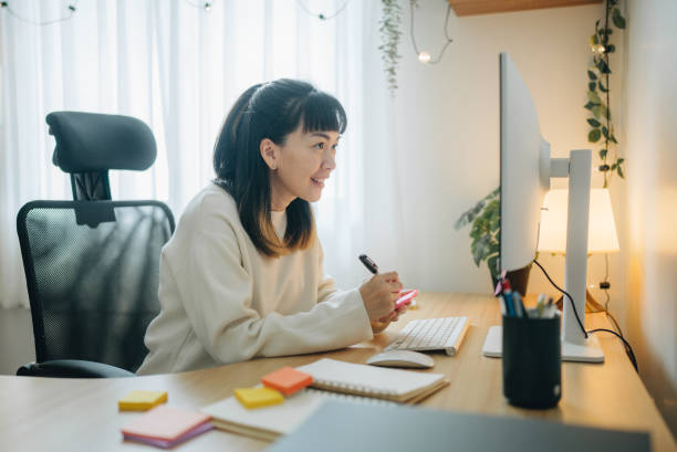 istock young Asian woman writing on notebook while working in home office 1567671157