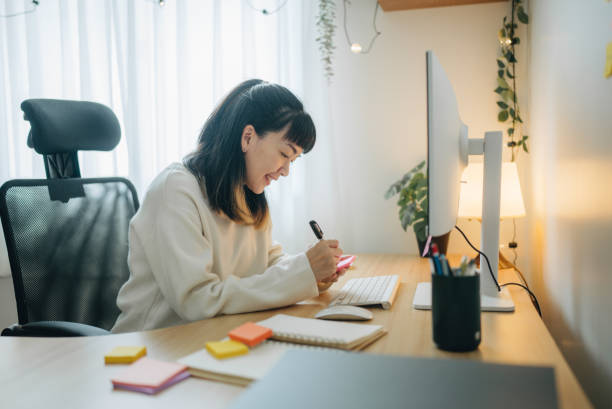 istock young Asian woman writing on notebook while working in home office 1567671169