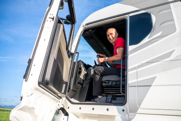 istock Smiling truck driver looking from cabin 1567674450