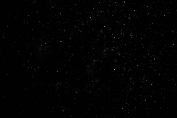 istock White snow falling in black night sky in the dark 1567674481