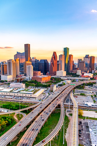 Interstate 45 as it moves southbound toward Galveston past the modern skyline of Houston, Texas at sunset from an altitude of about 600 feet.