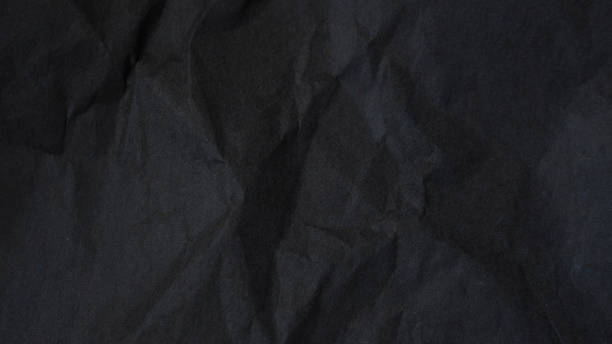 Dark abstract textile background texture. Black crumbled paper texture. stock photo