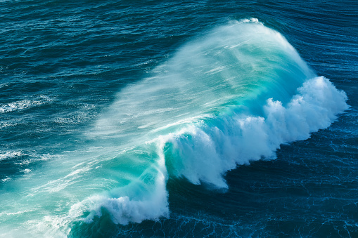 Turquoise perfect waves in ocean. Breaking wave ideal for surfing