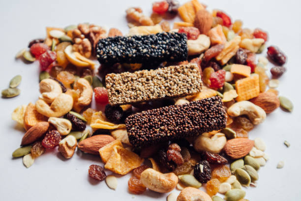 Various types of useful cereals and dried fruit bars on a white background surrounded by grains. Healthy food and weight loss. healthy snack ideas