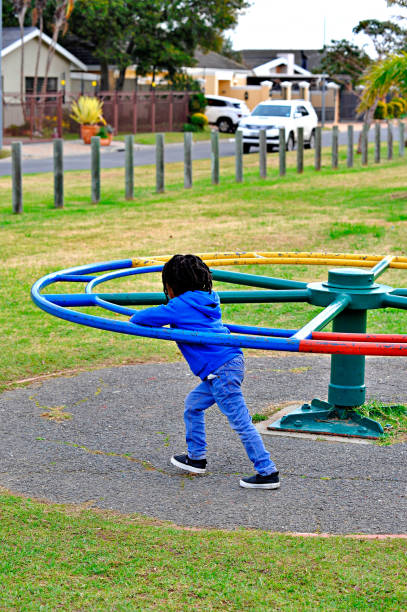 beautiful young black African boy with dreadlocks playing in a park .