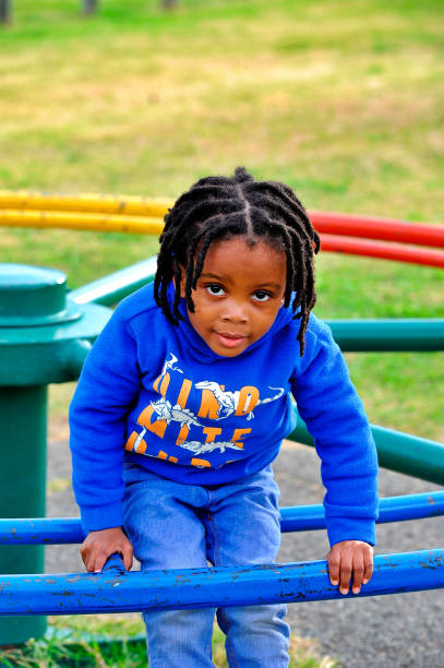 istock beautiful young black African boy with dreadlocks playing in a park . 1567764595